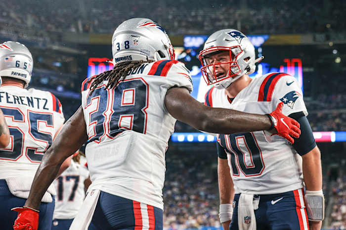 New England Patriots running back Rhamondre Stevenson (38) celebrates his touchdown with quarterback Mac Jones (10) during the second half against the New York Giants at MetLife Stadium.